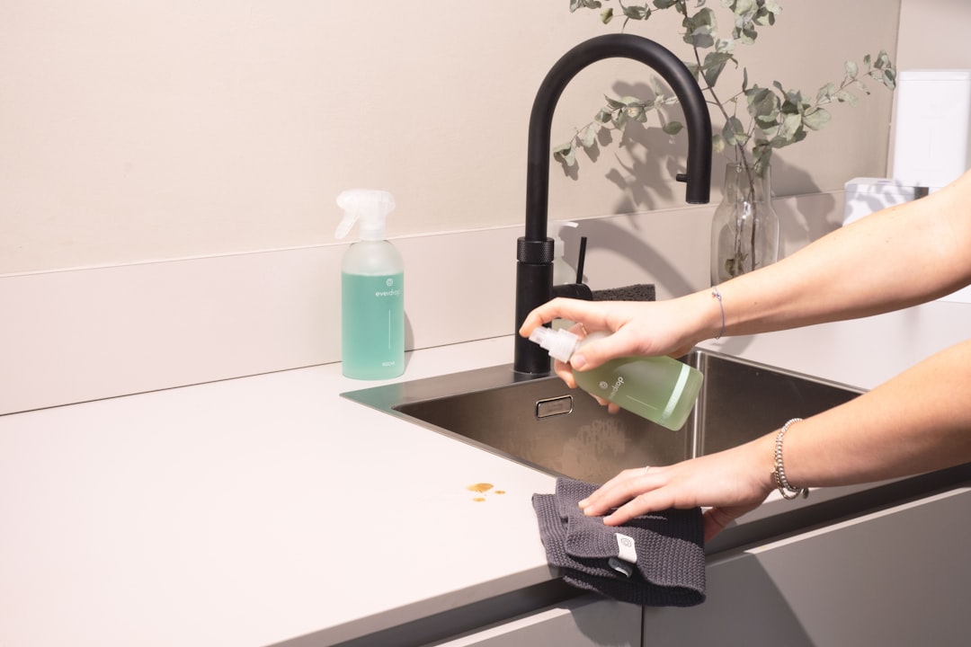 team-02 a-woman-is-cleaning-a-kitchen-sink-with-a-rag-sqomdoqb3ws